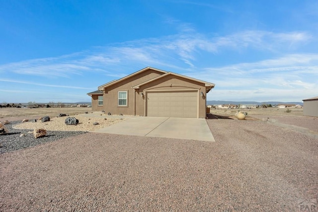 view of front facade featuring concrete driveway, a garage, and stucco siding