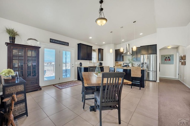 dining space featuring vaulted ceiling, arched walkways, recessed lighting, and light tile patterned floors