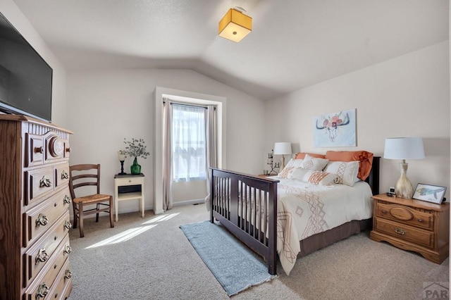 bedroom featuring lofted ceiling and light carpet