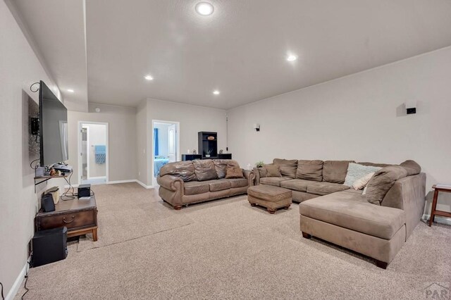 carpeted living area with baseboards and recessed lighting