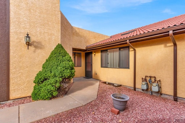 property entrance featuring stucco siding and a tiled roof