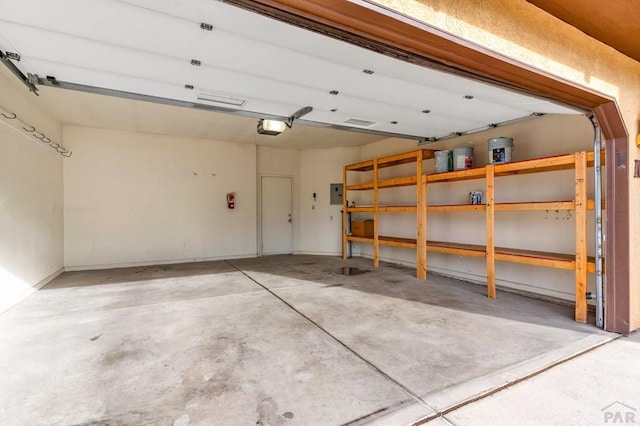 garage with electric panel and a garage door opener