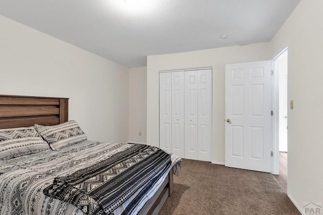 bedroom with dark colored carpet and a closet