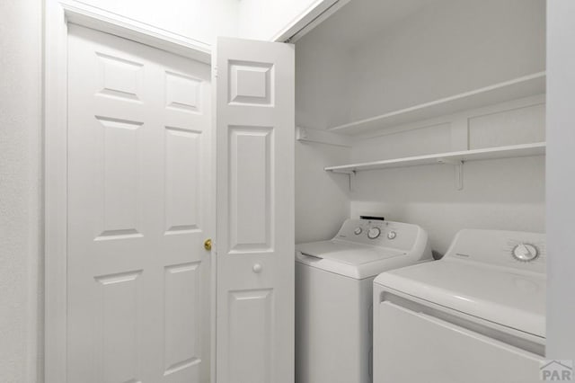 clothes washing area featuring laundry area and washing machine and clothes dryer