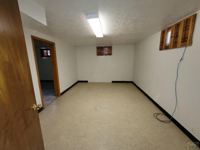 finished below grade area with a textured ceiling and baseboards