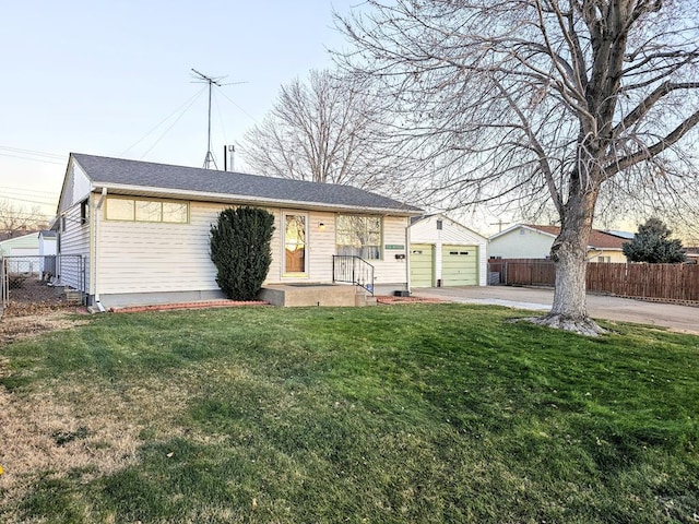 single story home with a front yard, fence, and a detached garage