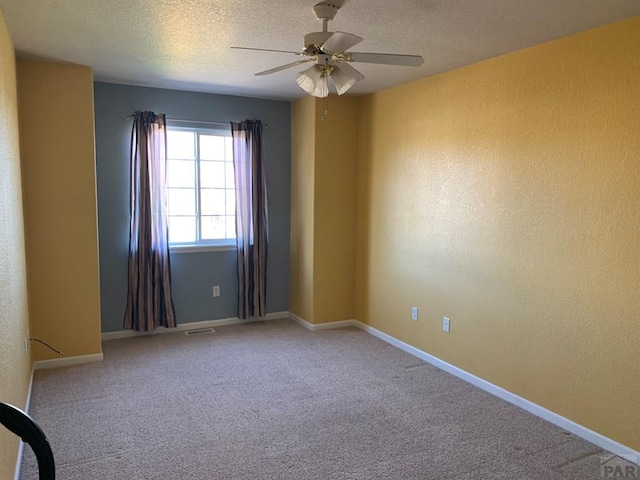 unfurnished room with baseboards, visible vents, ceiling fan, a textured ceiling, and carpet flooring