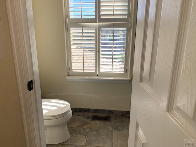 bathroom with toilet and visible vents