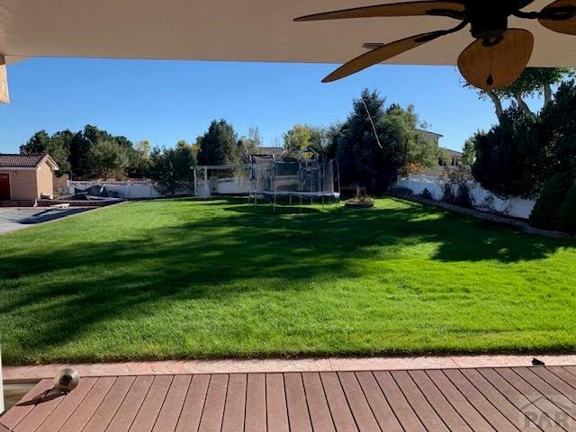 view of yard featuring a trampoline and fence private yard