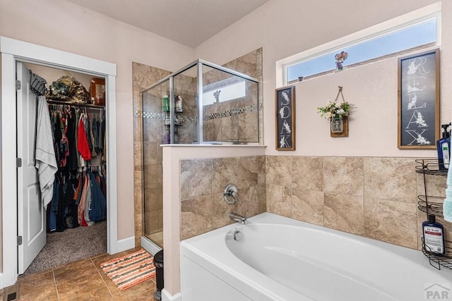 3327 Lions Pride Ln, Pueblo, CO 81005 - full bathroom featuring a bath, a shower stall, and a walk in closet