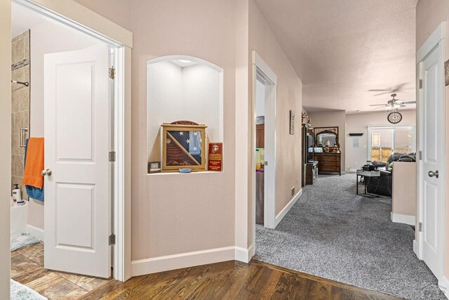 3327 Lions Pride Ln, Pueblo, CO 81005 - hall with arched walkways, baseboards, and wood finished floors