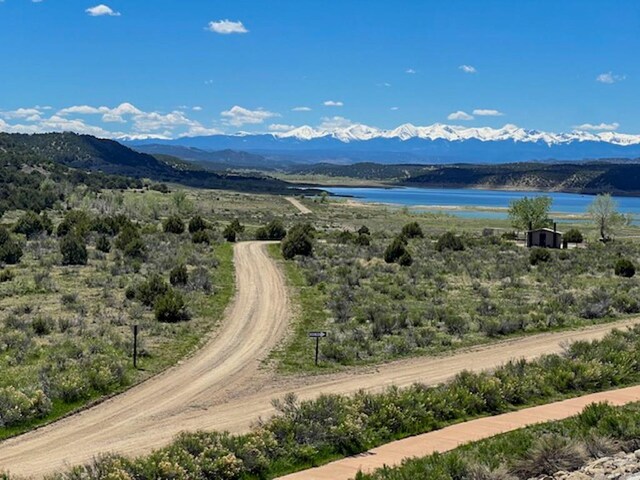 drone / aerial view featuring a water and mountain view