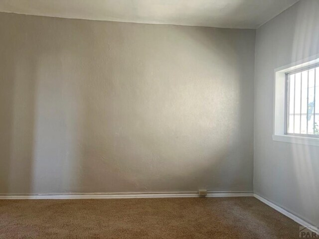 unfurnished room featuring carpet flooring and baseboards