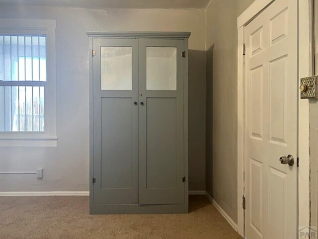 interior space featuring carpet and baseboards