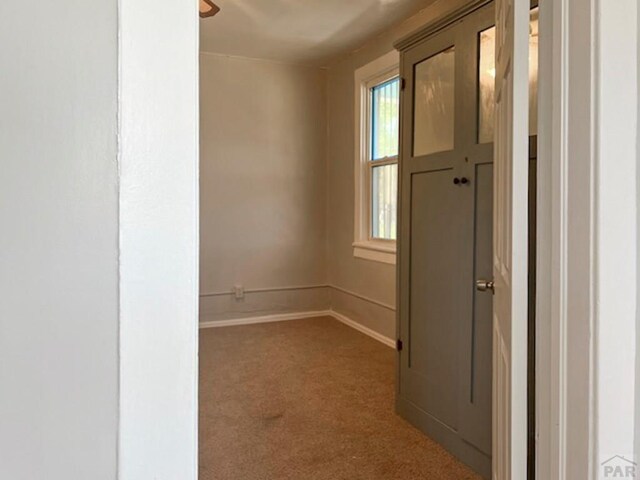 unfurnished room with carpet and baseboards