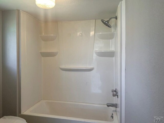 bathroom featuring toilet and bathing tub / shower combination