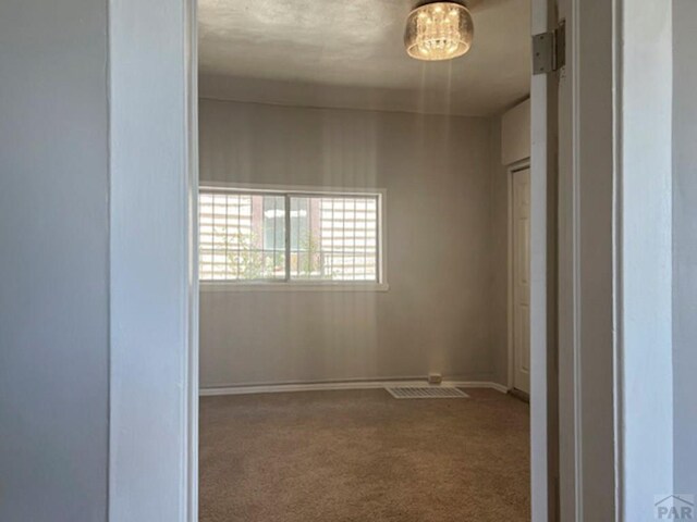 carpeted empty room with visible vents and baseboards