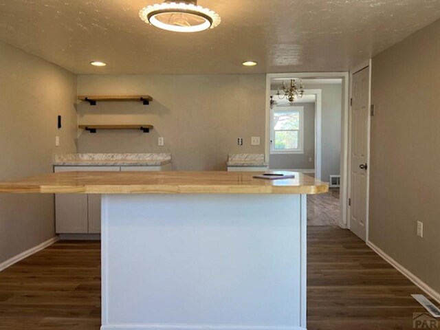 kitchen with white cabinets, dark wood finished floors, baseboards, and open shelves