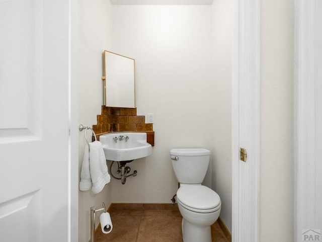 1040 28th Ln, Pueblo, CO 81006 - bathroom featuring toilet, tile patterned flooring, and a sink
