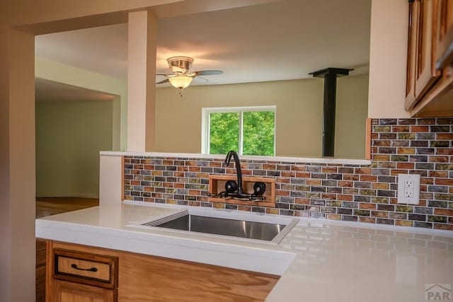 202 Pinon St, Walsenburg, CO 81089 - kitchen with backsplash, ceiling fan, light countertops, and brown cabinetry