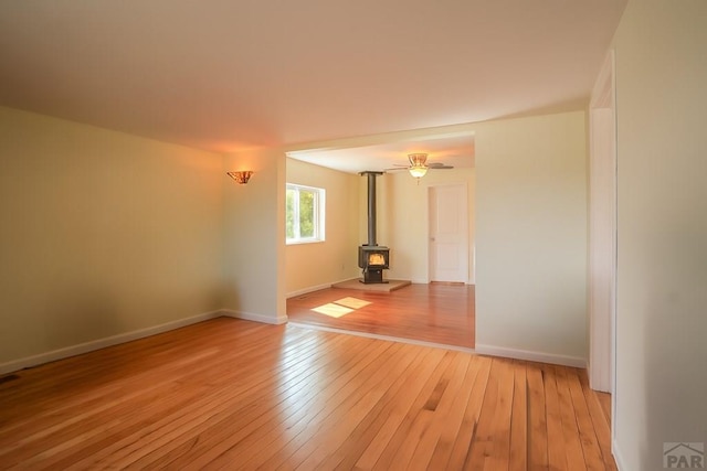202 Pinon St, Walsenburg, CO 81089 - empty room featuring a wood stove and light wood-style floors