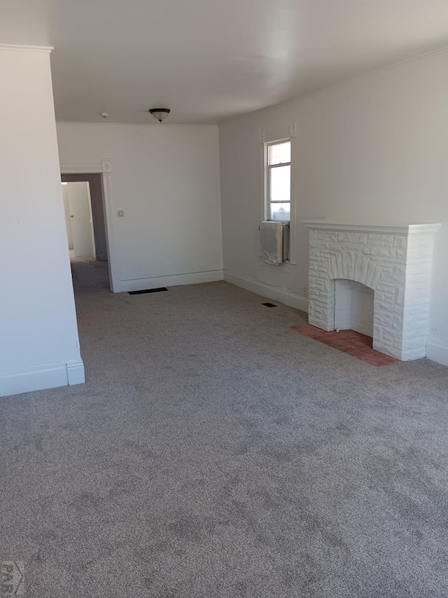 unfurnished living room with a fireplace with flush hearth, cooling unit, carpet flooring, and baseboards