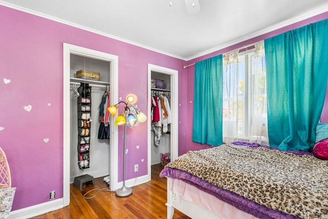 bedroom featuring baseboards, wood finished floors, and ornamental molding