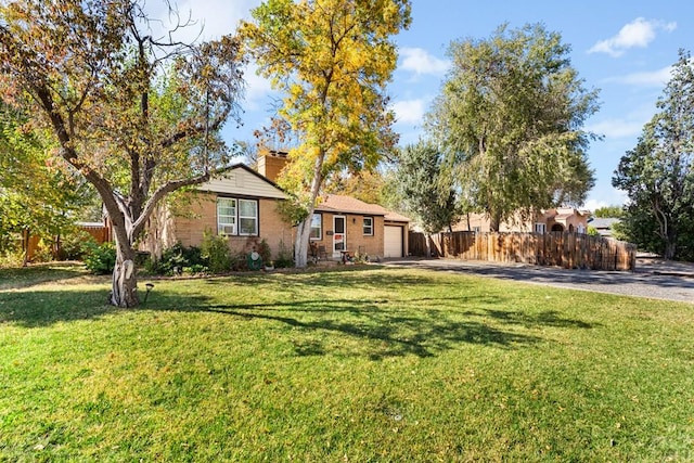 single story home with an attached garage, fence, driveway, a front lawn, and a chimney