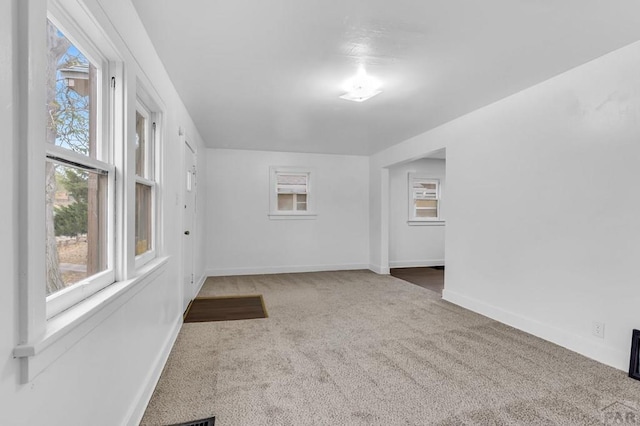 carpeted empty room with baseboards