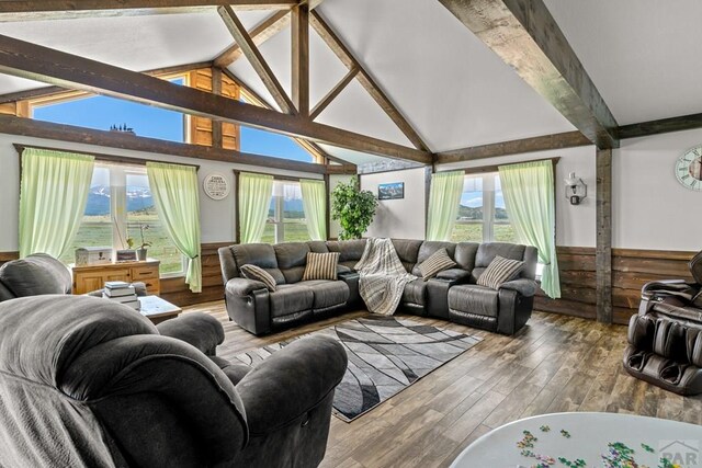 5010 Oak Grove Cir, Westcliffe, CO 81252 - living area with lofted ceiling with beams, a wealth of natural light, wood finished floors, and wainscoting