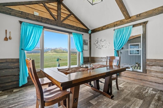 5010 Oak Grove Cir, Westcliffe, CO 81252 - dining area featuring a wainscoted wall, lofted ceiling with beams, wood walls, a mountain view, and wood finished floors
