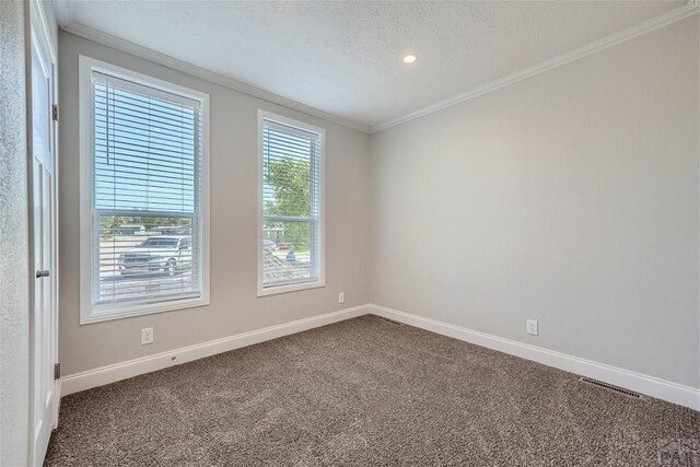 spare room with carpet floors, crown molding, and baseboards