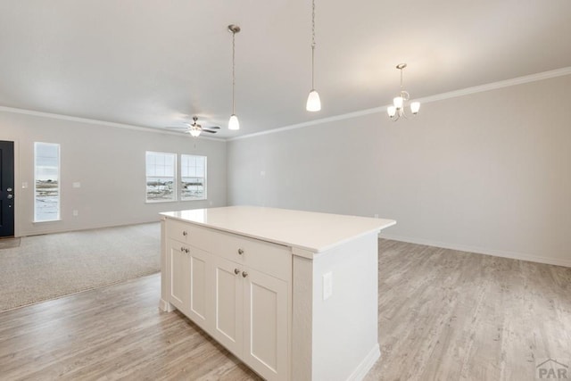 kitchen with pendant lighting, light countertops, open floor plan, white cabinetry, and a kitchen island