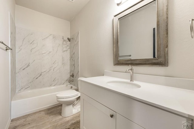 full bathroom featuring shower / bath combination, vanity, toilet, and wood finished floors