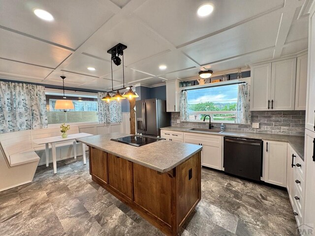 303 S Animas St, Trinidad, CO 81082 - kitchen with dishwashing machine, stainless steel fridge with ice dispenser, black electric stovetop, a center island, and white cabinets