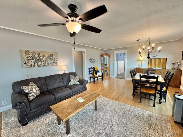 303 S Animas St, Trinidad, CO 81082 - living area featuring light wood-style floors, a textured ceiling, ceiling fan, a chandelier, and crown molding