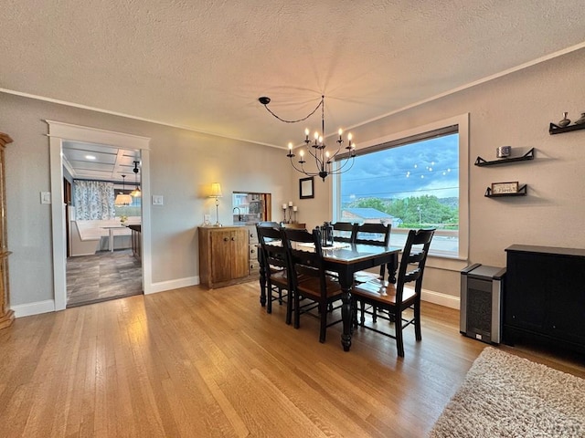 303 S Animas St, Trinidad, CO 81082 - dining area with light wood-type flooring, a textured ceiling, a chandelier, and ornamental molding