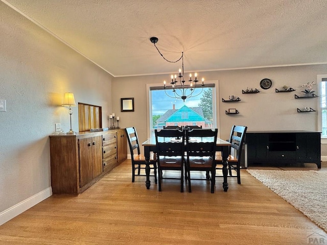 303 S Animas St, Trinidad, CO 81082 - dining space with a chandelier, a textured ceiling, light wood-style flooring, plenty of natural light, and a textured wall