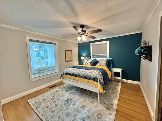 303 S Animas St, Trinidad, CO 81082 - bedroom with wood finished floors, crown molding, a ceiling fan, and a textured ceiling