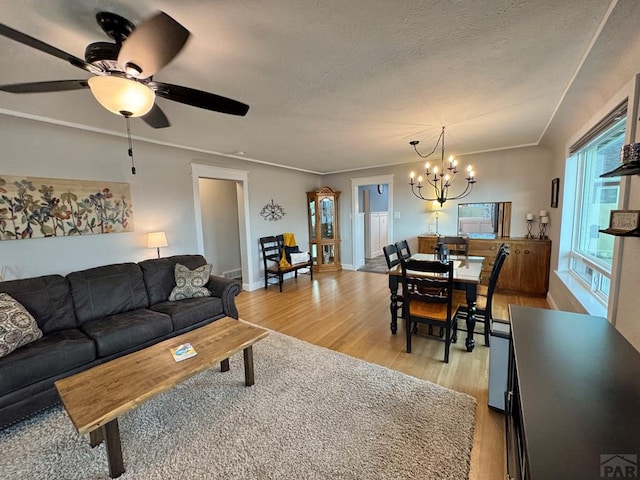 303 S Animas St, Trinidad, CO 81082 - living area with light wood finished floors, a chandelier, ceiling fan, and a textured ceiling