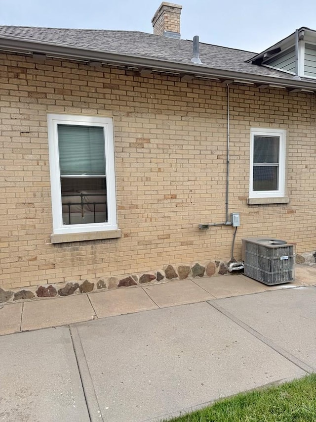 303 S Animas St, Trinidad, CO 81082 - view of side of property with brick siding, roof with shingles, a patio, and a chimney