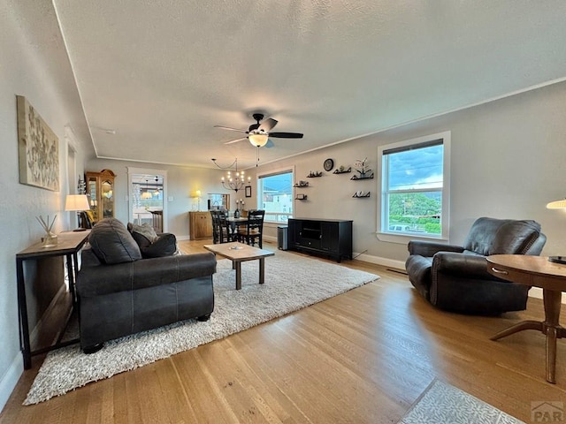 303 S Animas St, Trinidad, CO 81082 - living room featuring wood finished floors, a ceiling fan, a chandelier, and a textured ceiling