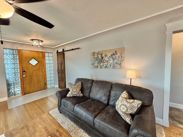 303 S Animas St, Trinidad, CO 81082 - living area featuring a barn door, wood finished floors, ceiling fan, and a textured ceiling
