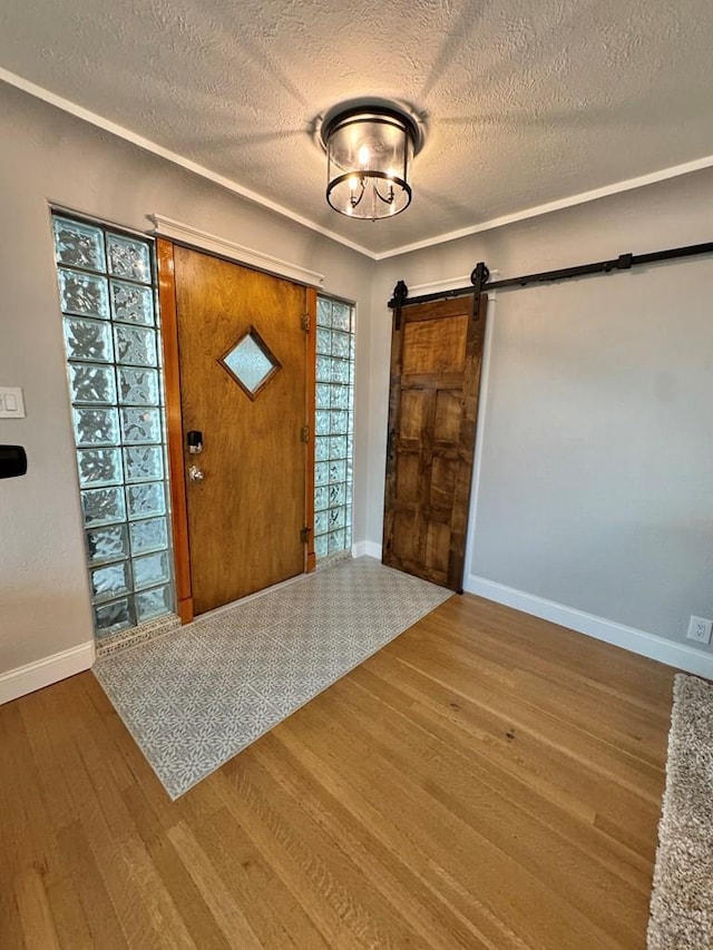 303 S Animas St, Trinidad, CO 81082 - foyer entrance with wood finished floors, a barn door, and a textured ceiling