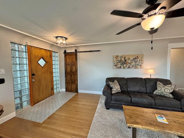 303 S Animas St, Trinidad, CO 81082 - living area featuring a barn door, wood finished floors, a ceiling fan, a textured ceiling, and crown molding