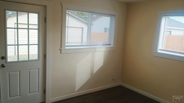 doorway to outside with dark wood finished floors and baseboards