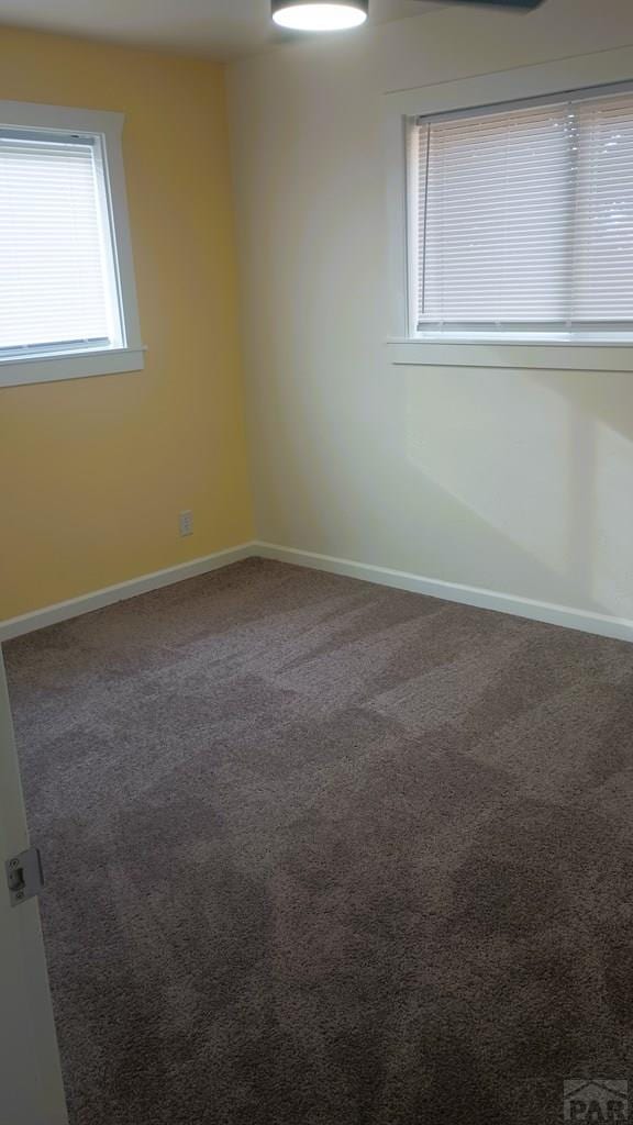 spare room featuring carpet floors and baseboards