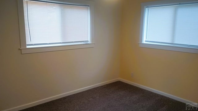 carpeted empty room with baseboards