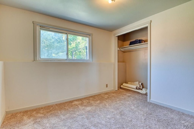 unfurnished bedroom with a closet, light carpet, and baseboards