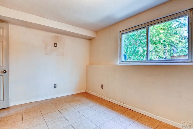 spare room with baseboards and light tile patterned flooring